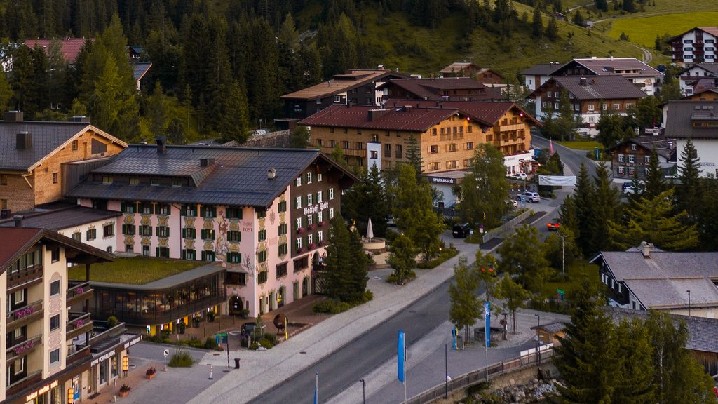 Directions | Getting to Hotel Post Lech Arlberg | Arrival & Travel Information View of village with mountain and forested slopes in the background under clear sky
