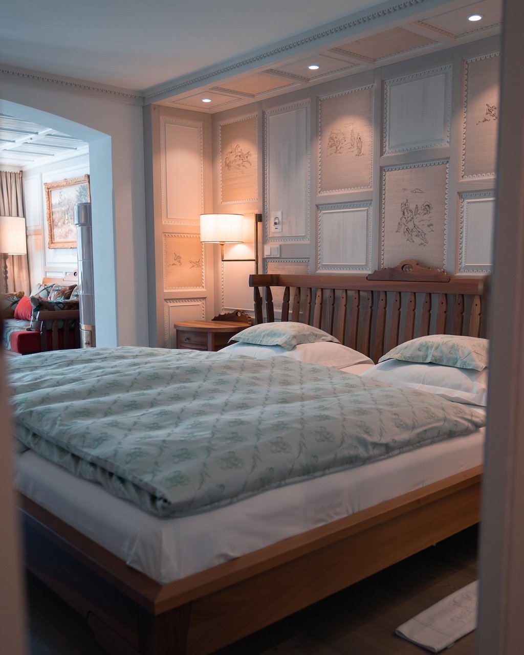 5-Sterne Hotel Post Lech Bett in einem stilvoll eingerichteten Schlafzimmer mit dekorativer Wandvertäfelung