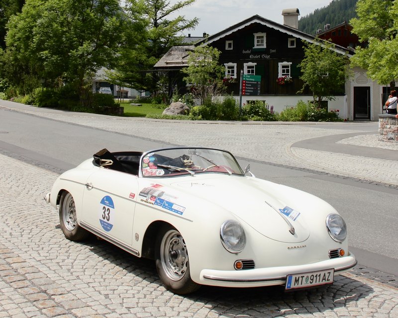 Neues aus der Post Weißer Porsche 356 Roadster parkt auf Kopfsteinpflasterstraße in Dorf
