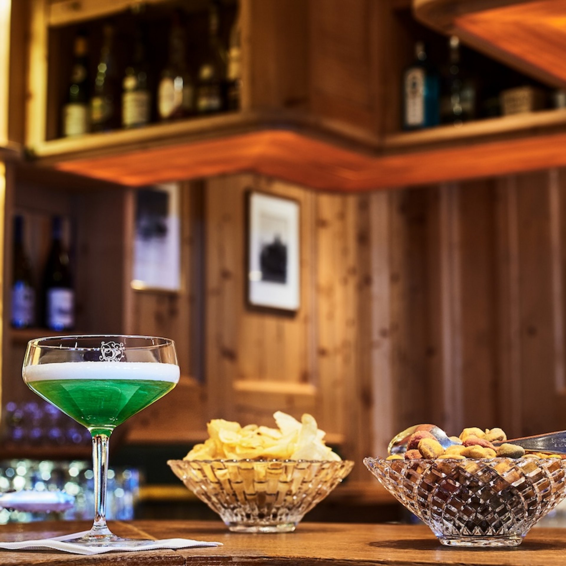 Dining at Hotel Post Lech | Restaurant in Lech Green beer with chips and nuts at a bar