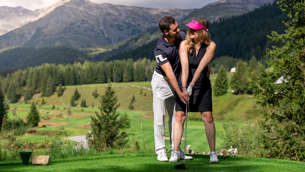 Golf Unlimited Couple playing golf with mountain landscape and green fields in the background