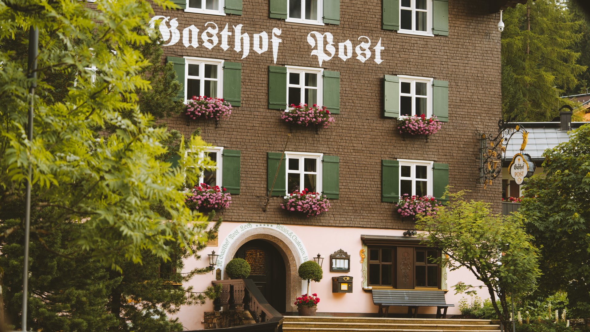 Hotel Post Lech am Arlberg Facade of Gasthof Post with green shutters and flower pots at windows