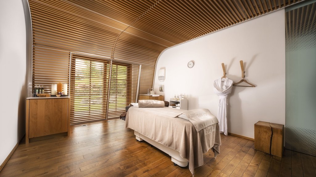 Day Spa im Hotel Post Lech Behandlungsraum mit Massageliege und Holzlamellendecke in warmem Licht