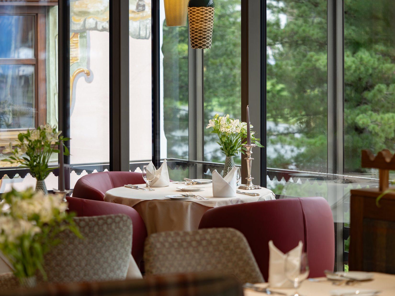 Impressions Elegant restaurant table with flowers, candle, and red seating area