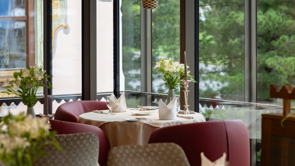 Indulge at Hotel Post Lech at the Arlberg | Alpine Luxury & Culinary Excellence Elegant restaurant table with flowers, candle, and red seating area