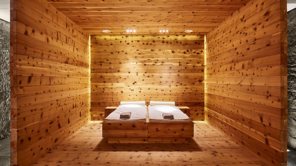 Hotel Post Lech am Arlberg Wooden sauna with two lounge chairs and warm lighting