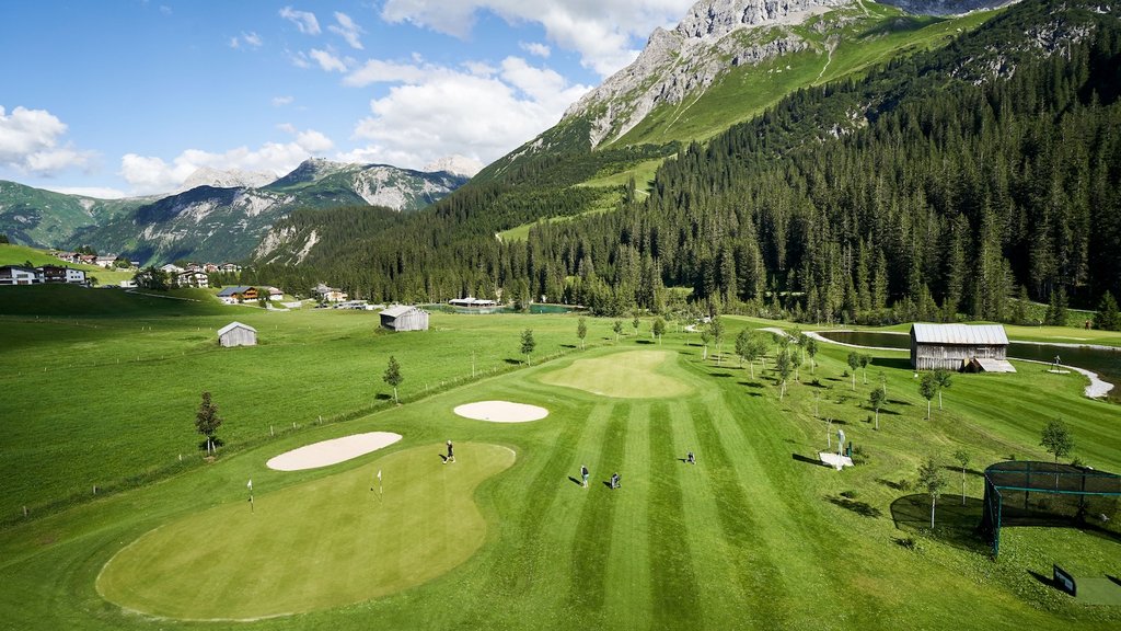 Sommer am Arlberg | Alpine Natur, Bewegung & Erholung im Hotel Post Lech Golfspieler auf grünem Golfplatz vor Alpenlandschaft mit Bergen und Wäldern