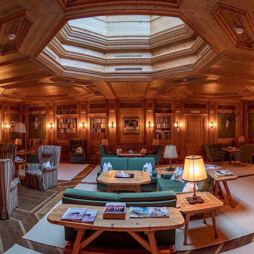 Events in Lech | Hotel Post Lech Arlberg Luxurious wood-paneled room with skylight, bookshelves, and cozy seating areas